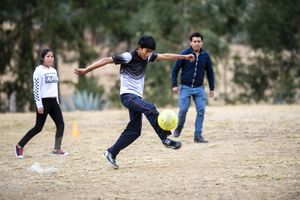 Rolando Rafael Fernandez (17) blüht beim Fußballspiel mit den Freunden auf - Jugendgruppe "Angeles de Shudal" trifft sich jeden Samstag auf dem Fußballplatz im Stadtteil Pacha Alta. Die Jugendlichen sind:  Rolando, 17 (graues T-Shirt mit Rolando-Schriftzug), Susan, 13 (bunte Leggin), Rosa, 14 (weißer Pullover), Ana Melva, 16 (Zopf), David, 15 (dunkle Jeans), Eber, 14 (blaue Jeans und Kaputzenpulliu), Bewegung „Micanto - José Obrero“, Cajamarca, Peru; Foto: Florian Kopp