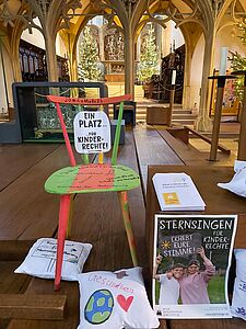 Dieser Stuhl wurde im Rahmen unserer Sternsingervorbereitungen von den Breisacher Sternsingern gestaltet. Durch seine bunte Farbgestaltung soll er auffallen und so auf die wichtigsten Kinderrechte aufmerksam machen, die die Kinder und Jugendlichen auf dem Stuhl notiert haben. 
Darüber hinaus hat jede Sternsingerin und jeder Sternsinger ein eigenes Sitzkissen bemalt. Darauf ist zu sehen, welche Kinderrechte den Kindern besonders wichtig sind. 
Im Rahmen des Sternsingergottesdienstes wurden diese vorgestellt und die ganze Gemeinde dazu aufgefordert, die Stimme für Kinderrechte zu erheben und die Aktion der Sternsinger zu unterstützen. // © Alexandra Hau