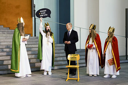 „Erhebt eure Stimme! – Sternsingen für Kinderrechte“ lautet das Motto der 67. Aktion Dreikönigssingen. Die Sternsingerinnen Maleen (13), Paula (13), Josefin (13) und Anna (10) aus dem pastoralen Raum Rietberg (Erzbistum Paderborn) stellten dem Bundeskanzler das Motto vor. Zudem überreichten sie ihm einen gelben Stuhl, der symbolisch einen Platz für Kinderrechte einfordert. // © Friedrich Stark / Kindermissionswerk